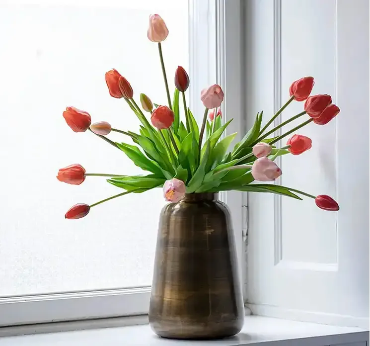 Kunstig tulipanbuket af gummi i pink vist i vindueskarm med anden farve tulipanbuket